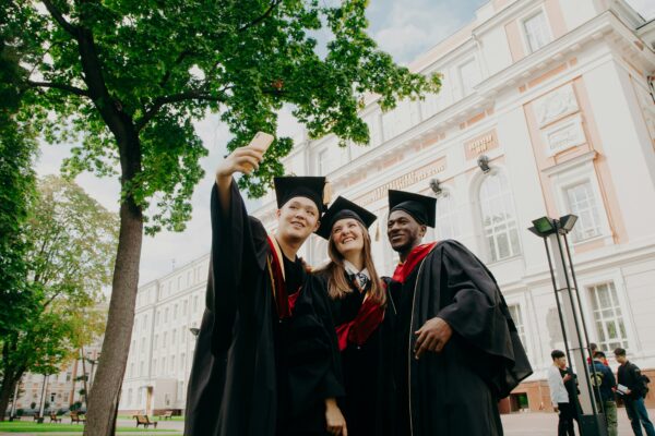 3 women in black academic dress standing near green tree during daytime