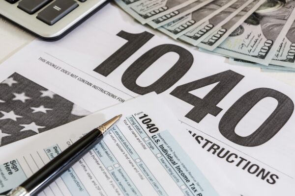 tax forms 1040 and calculator with dollars