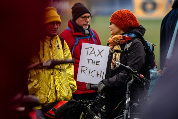 A person in a wheelchair holding a sign