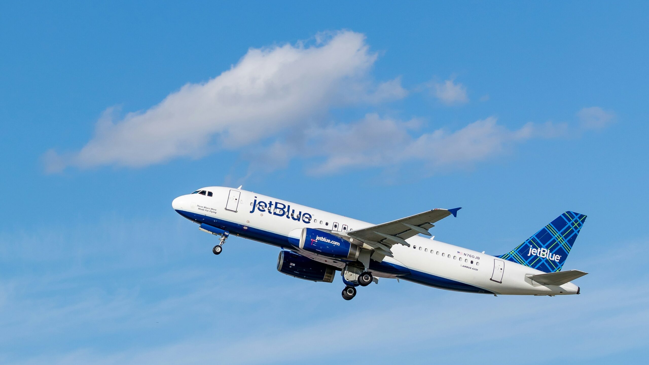 white and blue Jetblue airliner flying on sky