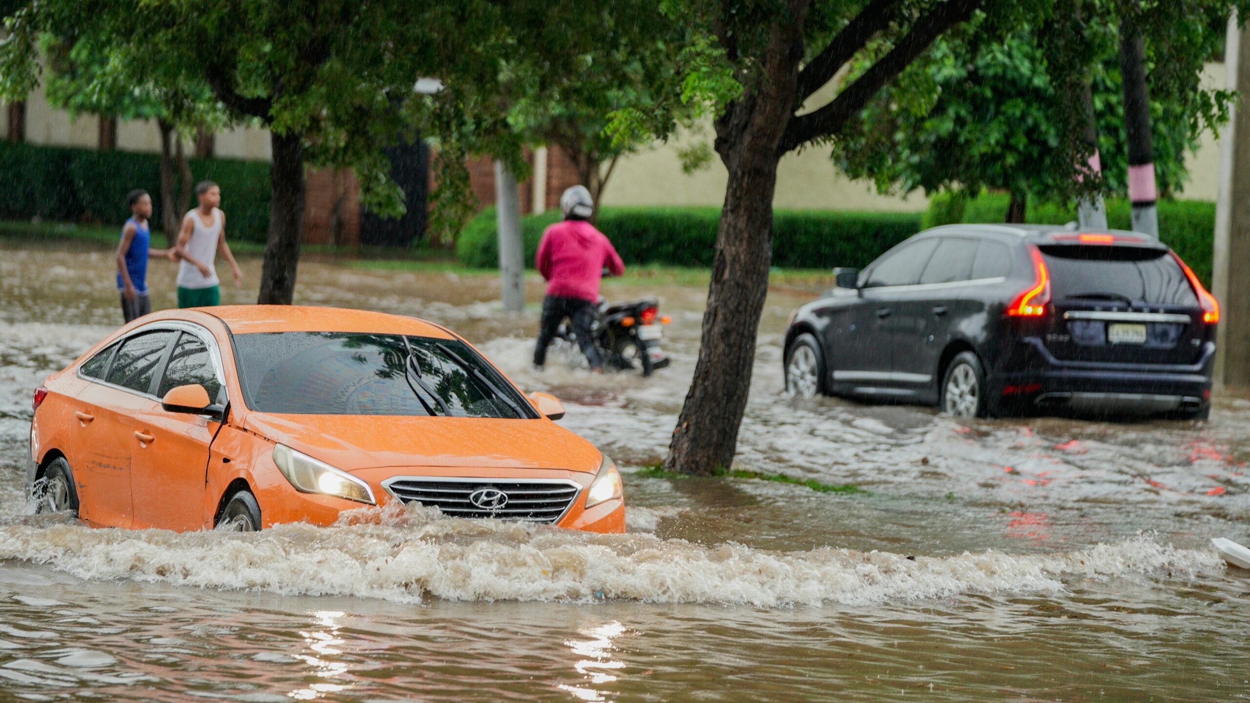 A group of people walking through a flooded street