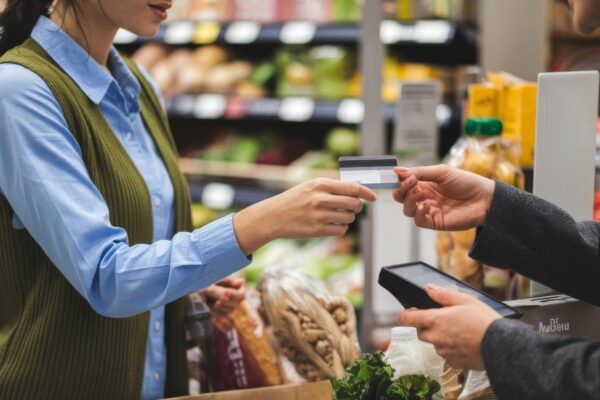 Woman paying for groceries front view