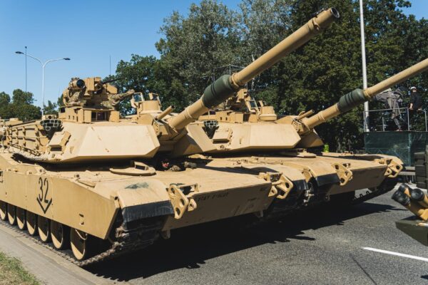 Focus on two m abrams main battle tanks driving in a column during an openair military parade in