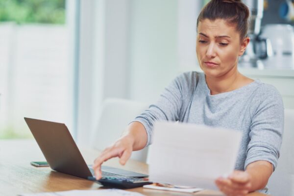Young woman counting home budget with bills
