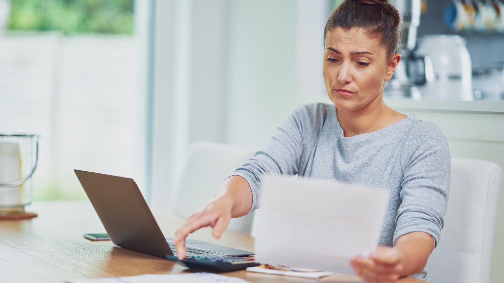 Young woman counting home budget with bills