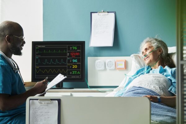 Middle aged black male doctor consulting senior caucasian female patient