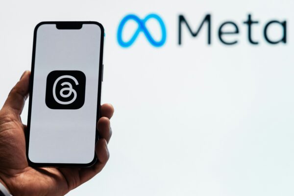 a person holding up a cell phone in front of a sign