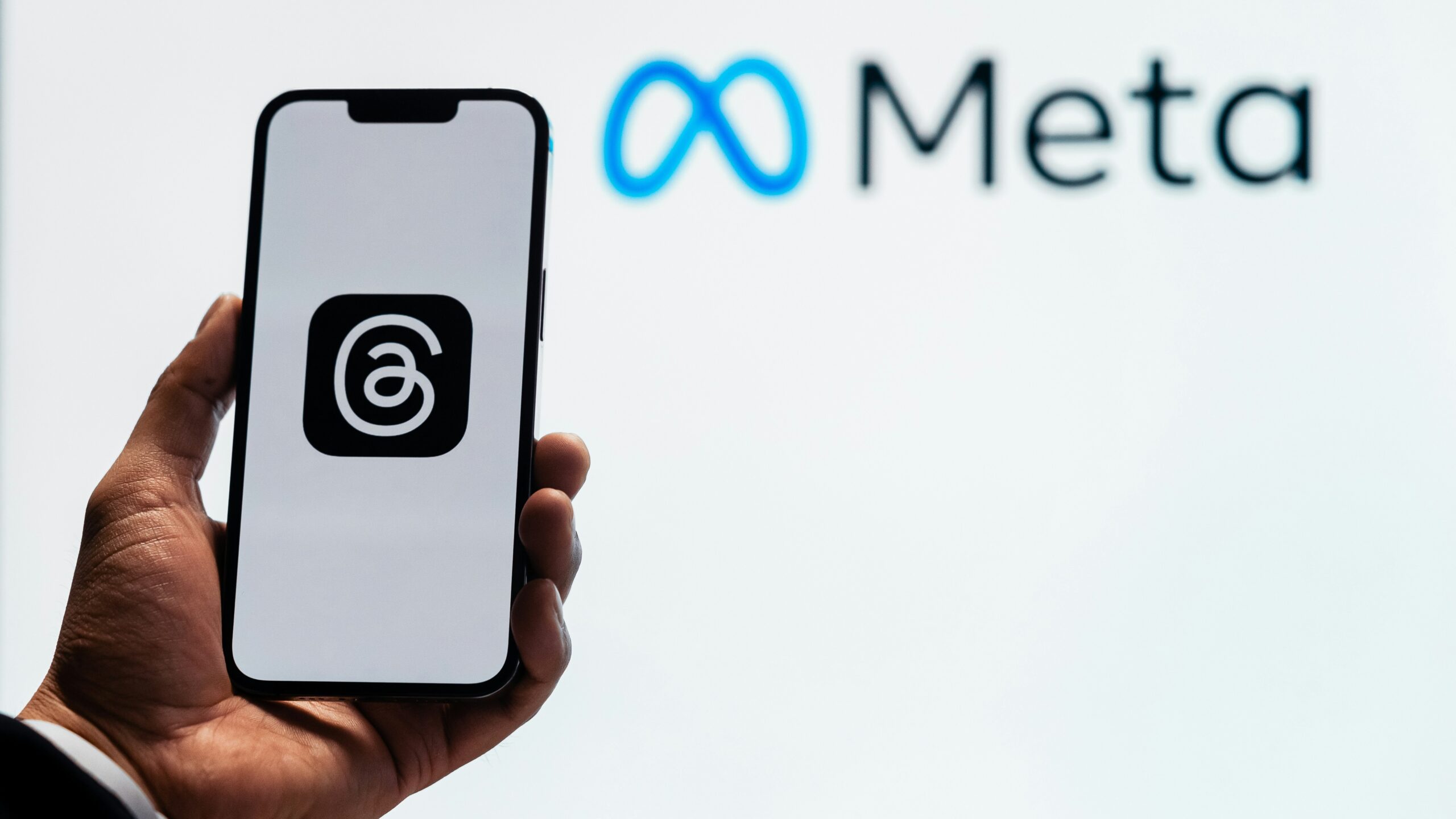 a person holding up a cell phone in front of a sign