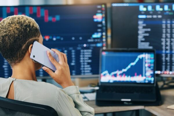 Woman phone call and broker consulting in trading stock market or discussion for online finance at office Business female person or financial advisor talking on mobile smartphone in advice or help