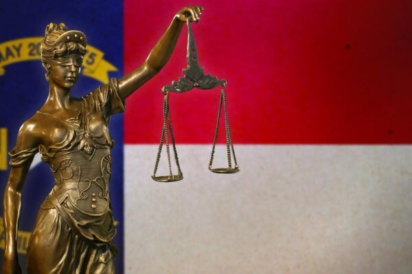Lady Justice before a flag of North Carolina