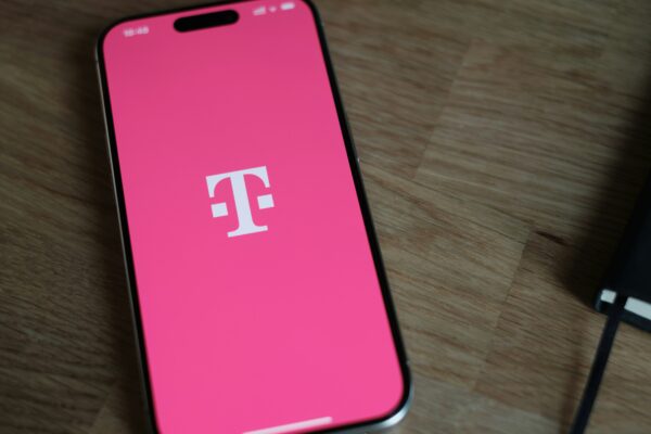 A pink phone sitting on top of a wooden table