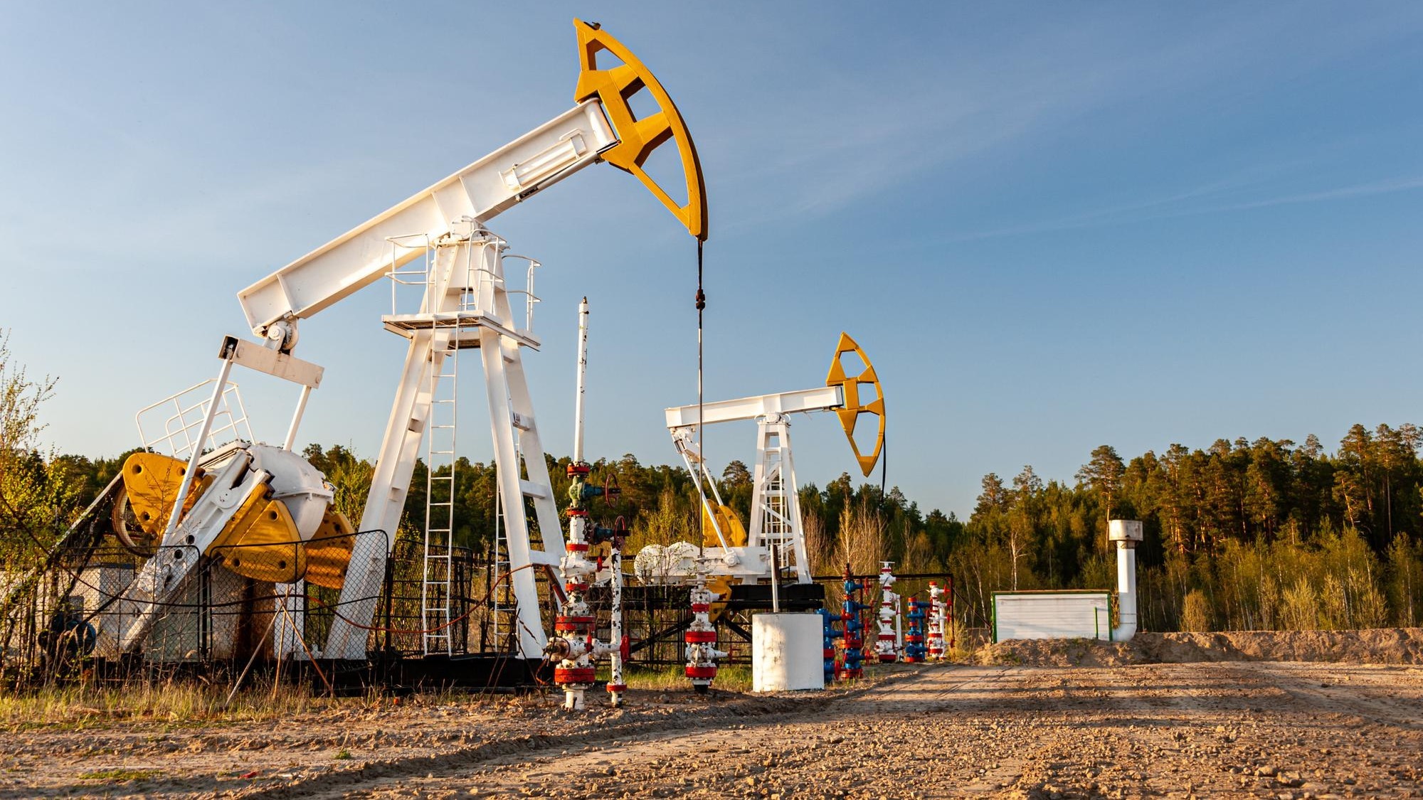 Oil pump rig. Oil and gas production. Oilfield site. Pump Jack are running. Drilling derricks for fossil fuels output and crude oil production. War on oil prices. Global coronavirus COVID 19 crisis.