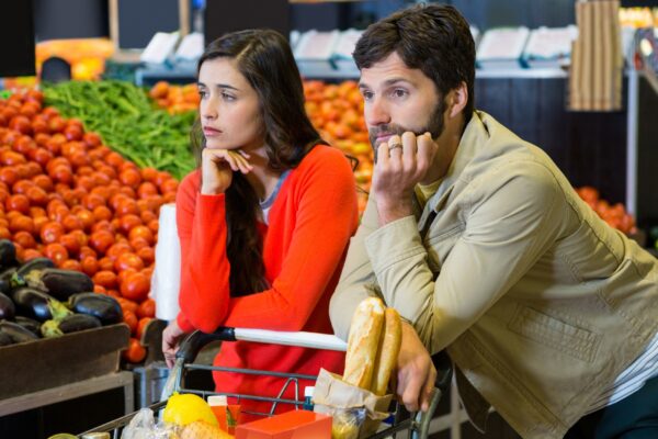 Bored couple with shopping trolley in organic section