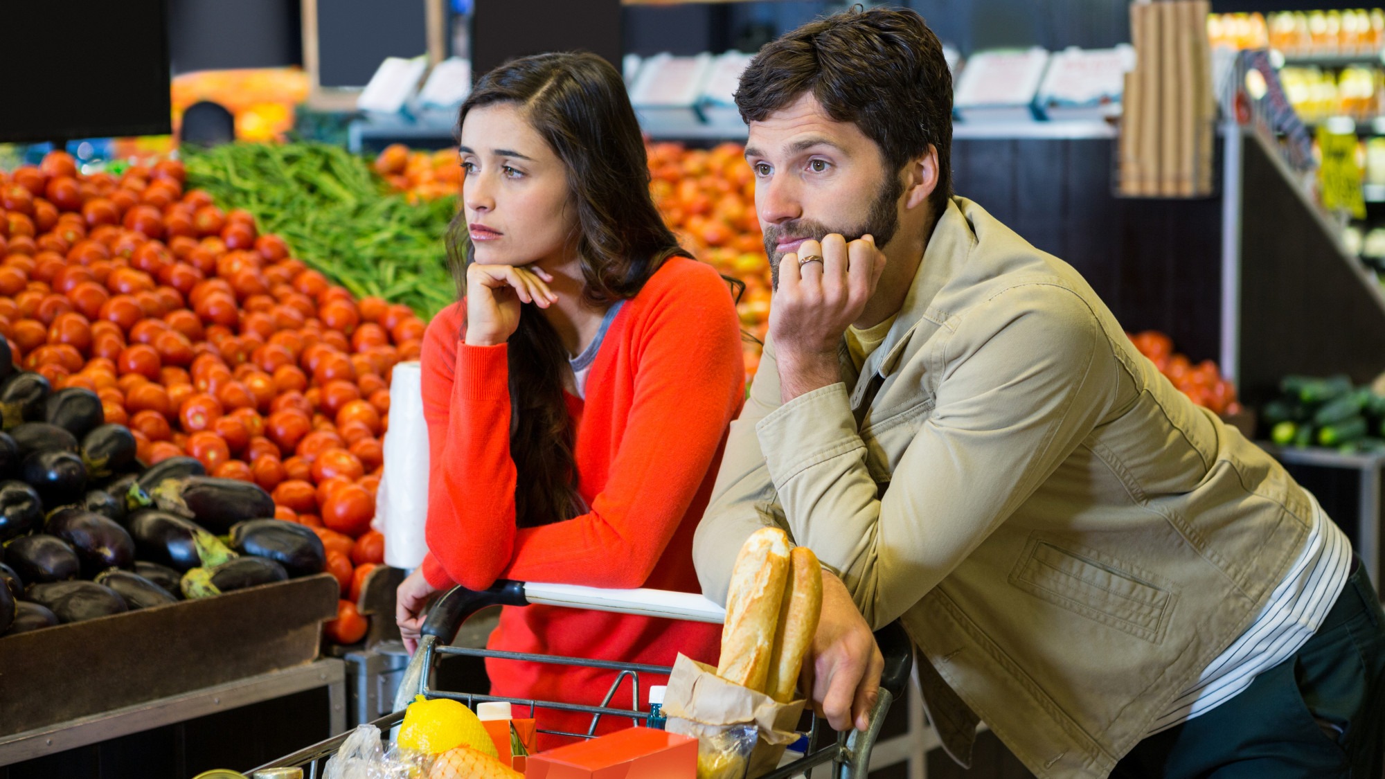 Bored couple with shopping trolley in organic section