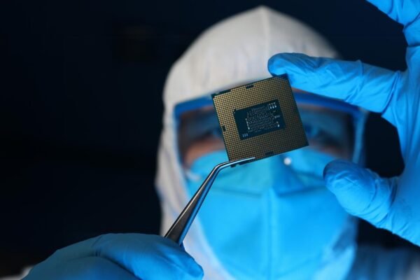 Man in uniform holds microprocessor with forceps