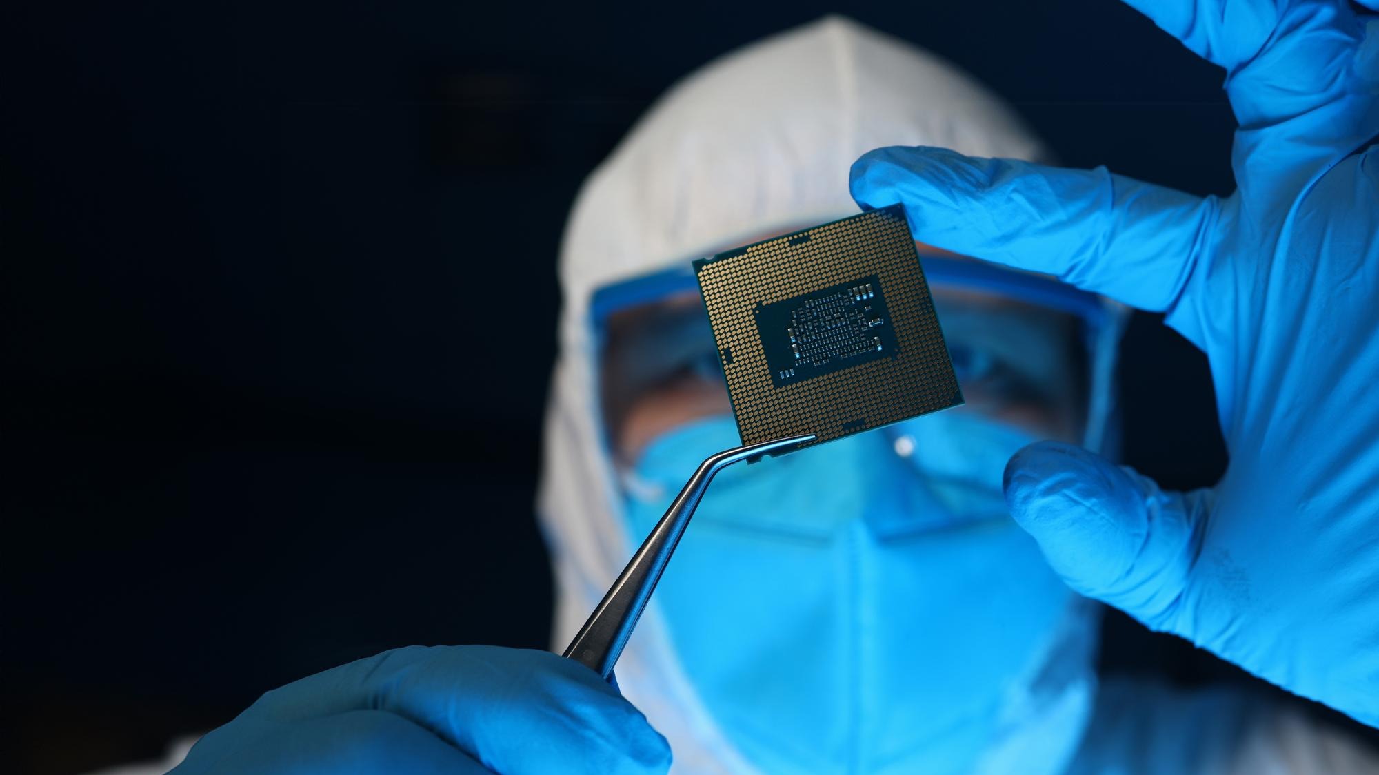 Man in uniform holds microprocessor with forceps
