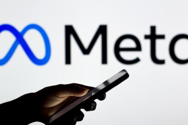 March 16 2022 Brazil In this photo illustration the Meta Platforms logo seen in the background of a silhouette woman holding a mobile phone