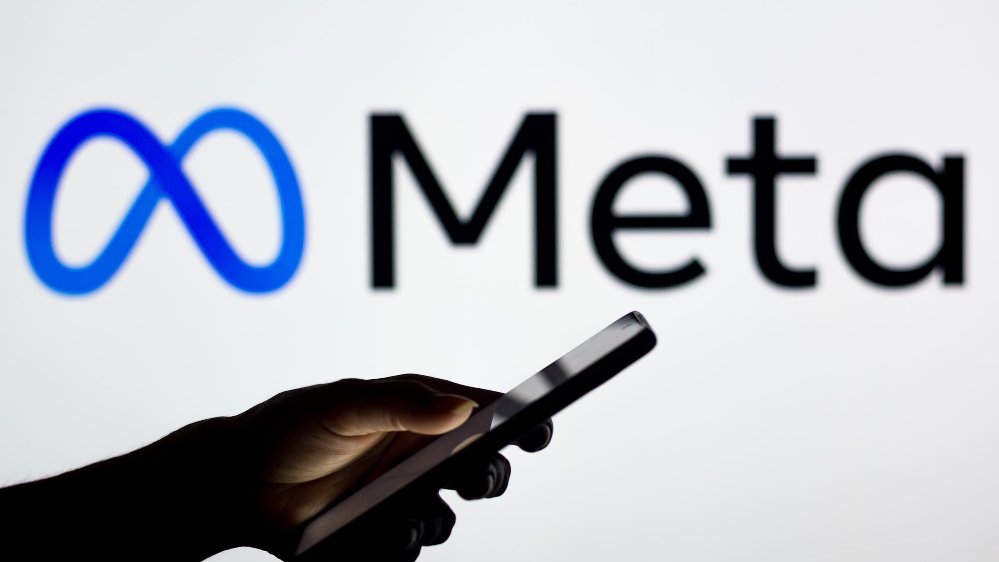 March 16 2022 Brazil In this photo illustration the Meta Platforms logo seen in the background of a silhouette woman holding a mobile phone