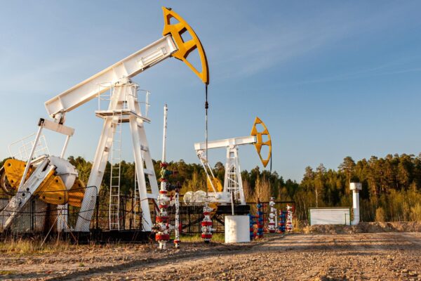 Oil pump rig. Oil and gas production. Oilfield site. Pump Jack are running. Drilling derricks for fossil fuels output and crude oil production. War on oil prices. Global coronavirus COVID 19 crisis.