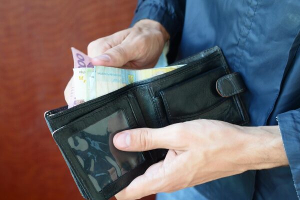 Midsection of man holding wallet