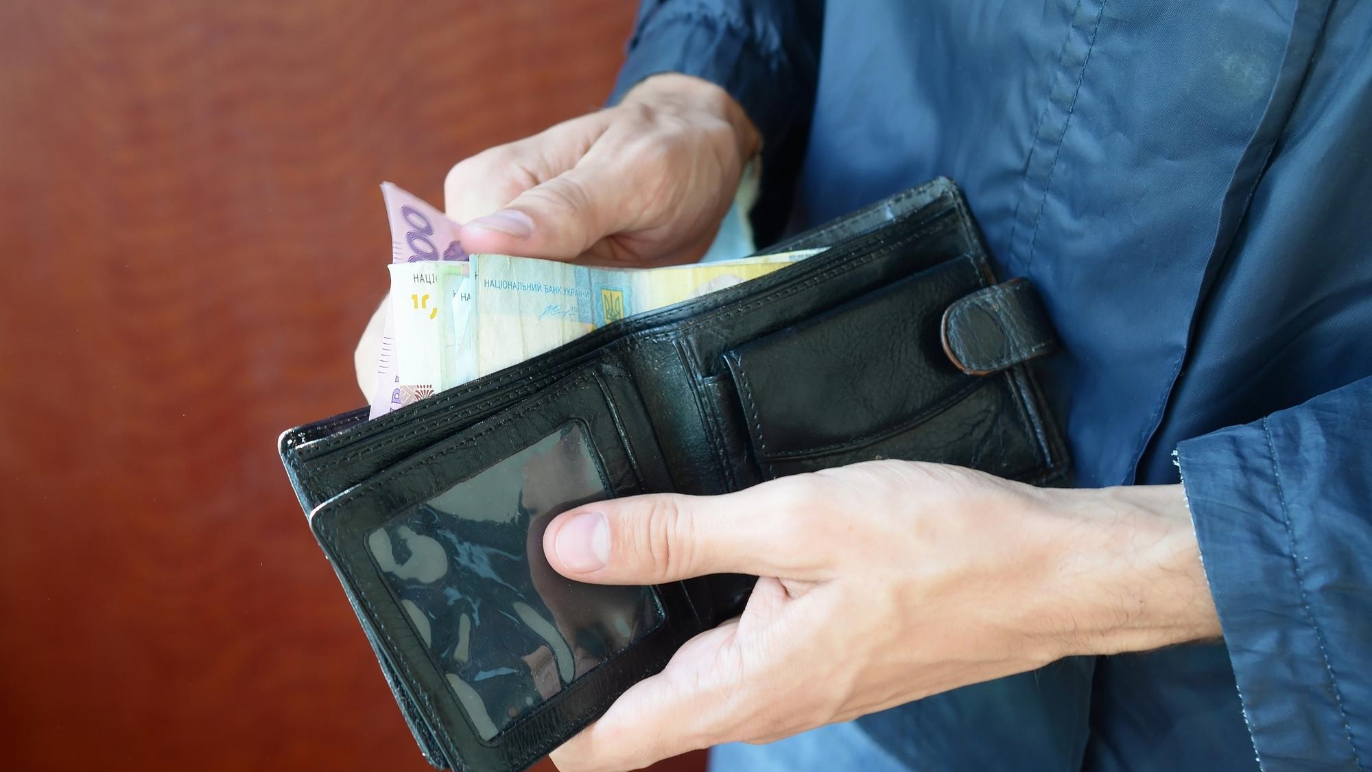 Midsection of man holding wallet