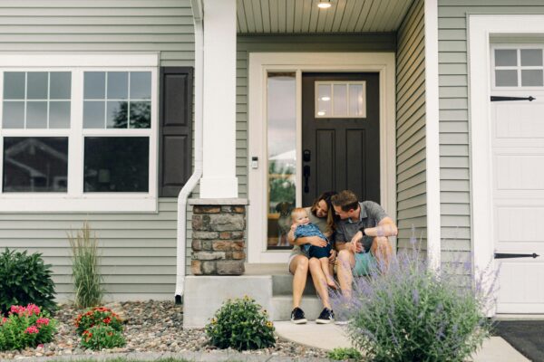a couple of people that are sitting in front of a house