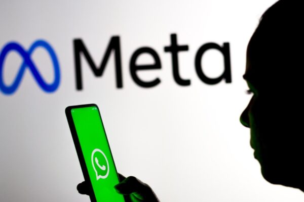 March 16 2022 Brazil In this photo illustration a woman holds a smartphone with the WhatsApp logo displayed on the screen with the Meta Platforms logo displayed in the background