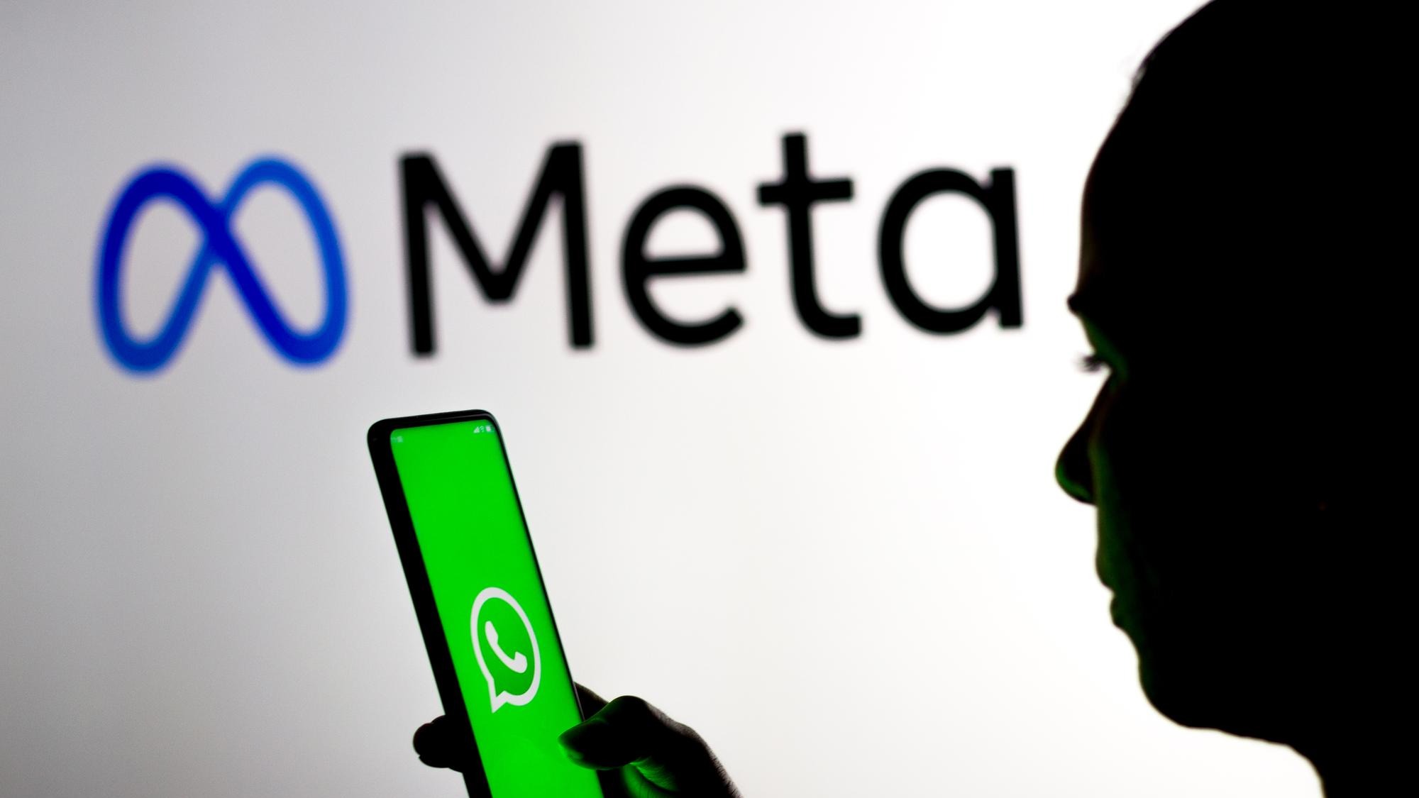 March 16 2022 Brazil In this photo illustration a woman holds a smartphone with the WhatsApp logo displayed on the screen with the Meta Platforms logo displayed in the background