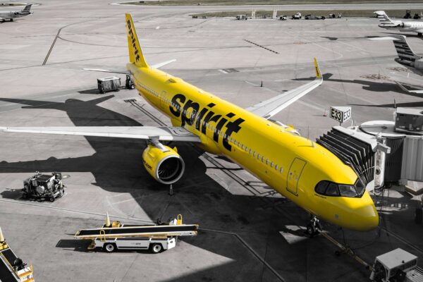A yellow spirit airlines airplane at the gate.