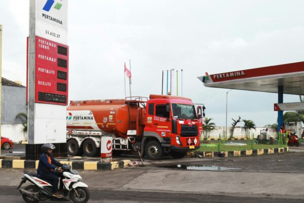 A red tanker truck at a gas station.