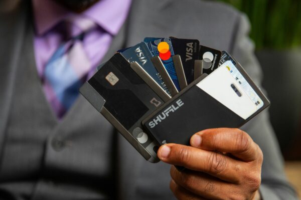 a man in a suit holding four credit cards