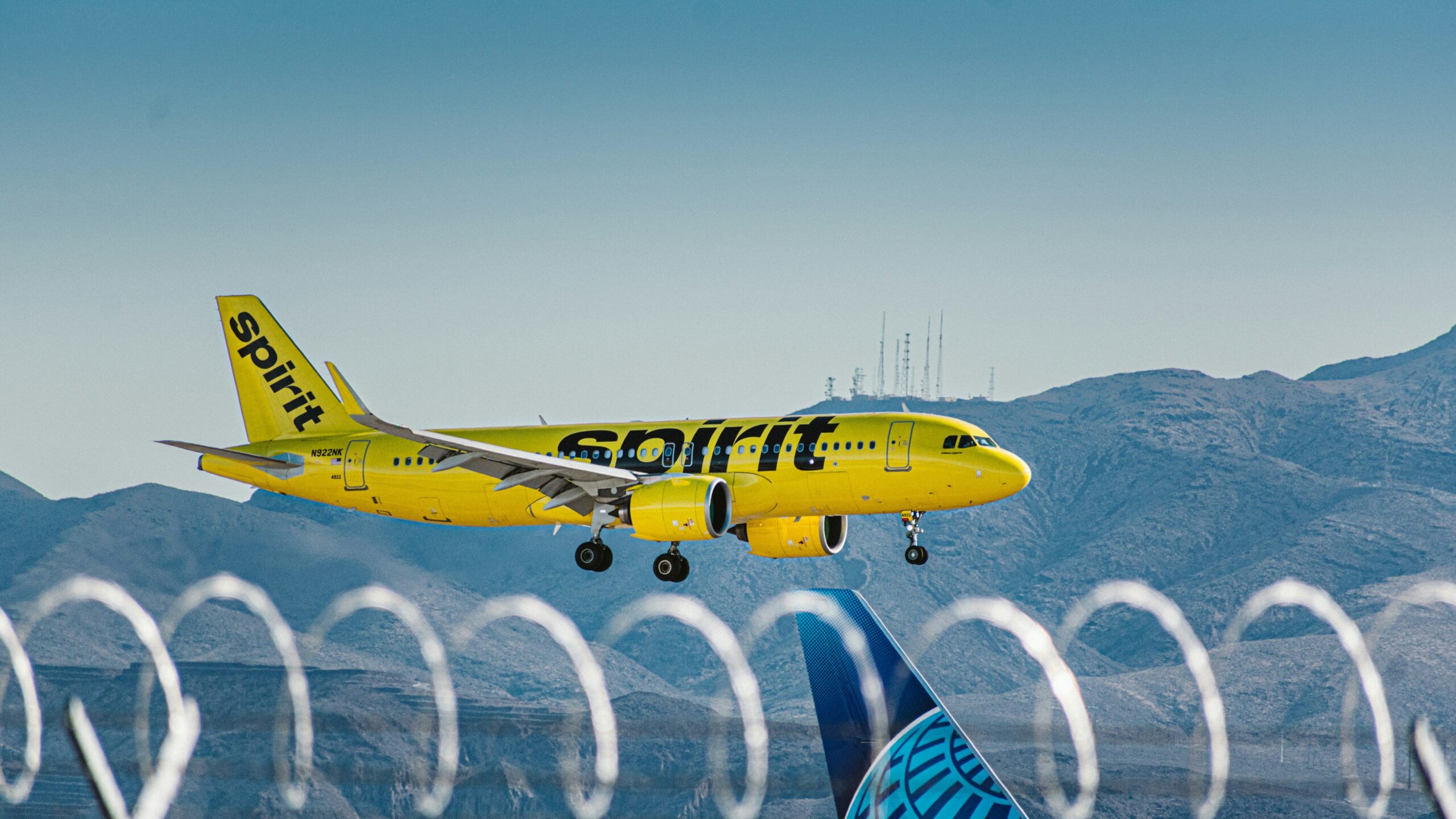 a yellow and blue jet airliner taking off from an airport