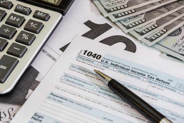 tax forms 1040 and calculator with dollars
