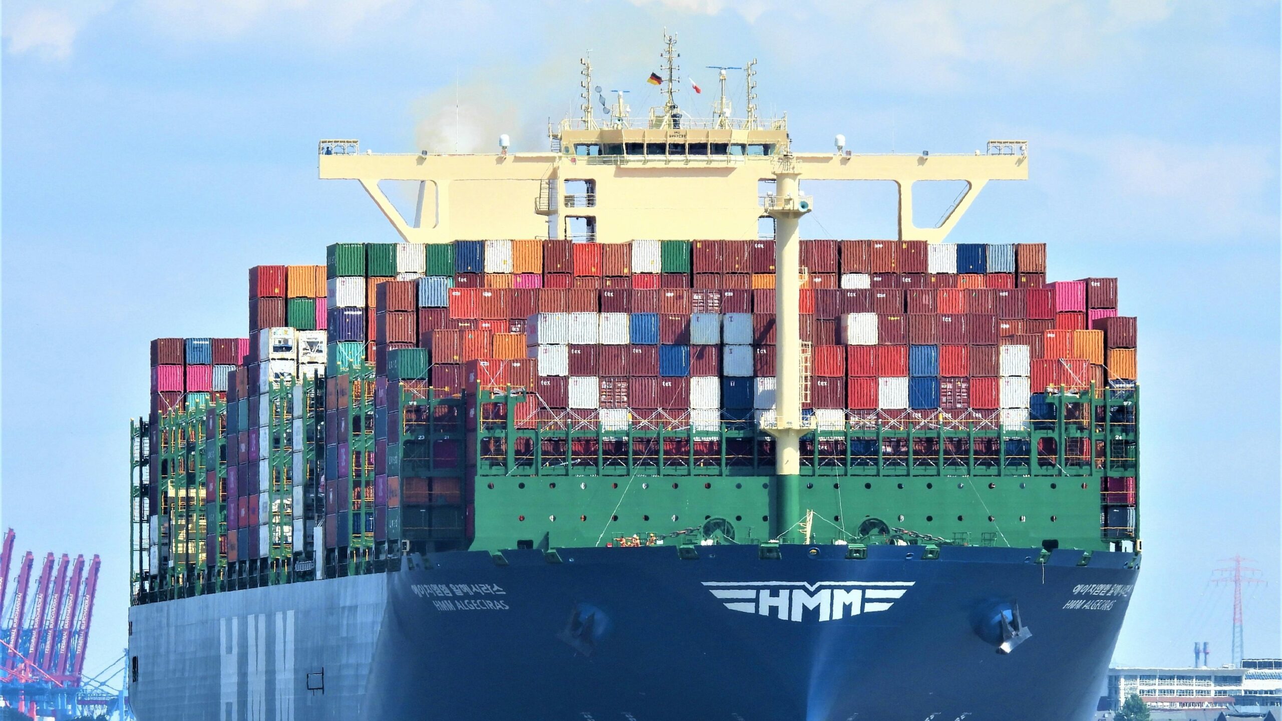 Front view of a massive cargo ship loaded with containers in Hamburg’s harbor.