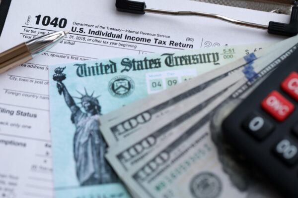 United States 1040 tax form individual income tax return with refund check and US dollar bills