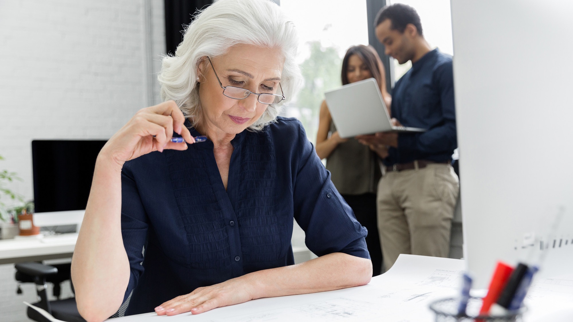 Mature businesswoman working with documents while sitting at her workplace