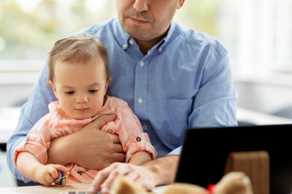 father with baby working at home