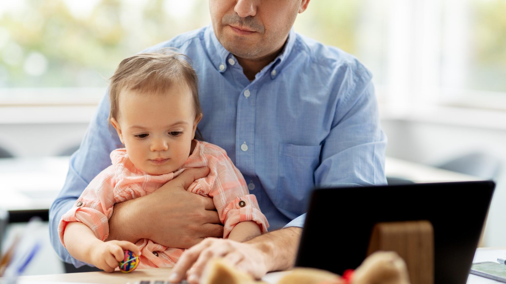 father with baby working at home