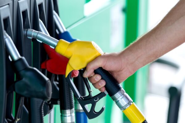 Pumping gas at gas pump. Closeup of man pumping gasoline fuel in car at gas station.