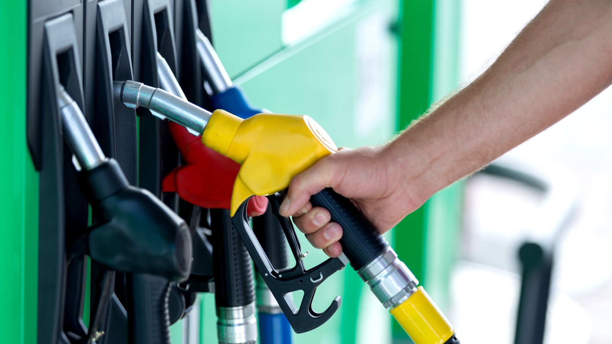 Pumping gas at gas pump. Closeup of man pumping gasoline fuel in car at gas station.