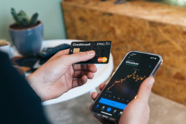a person holding a smart phone and a credit card