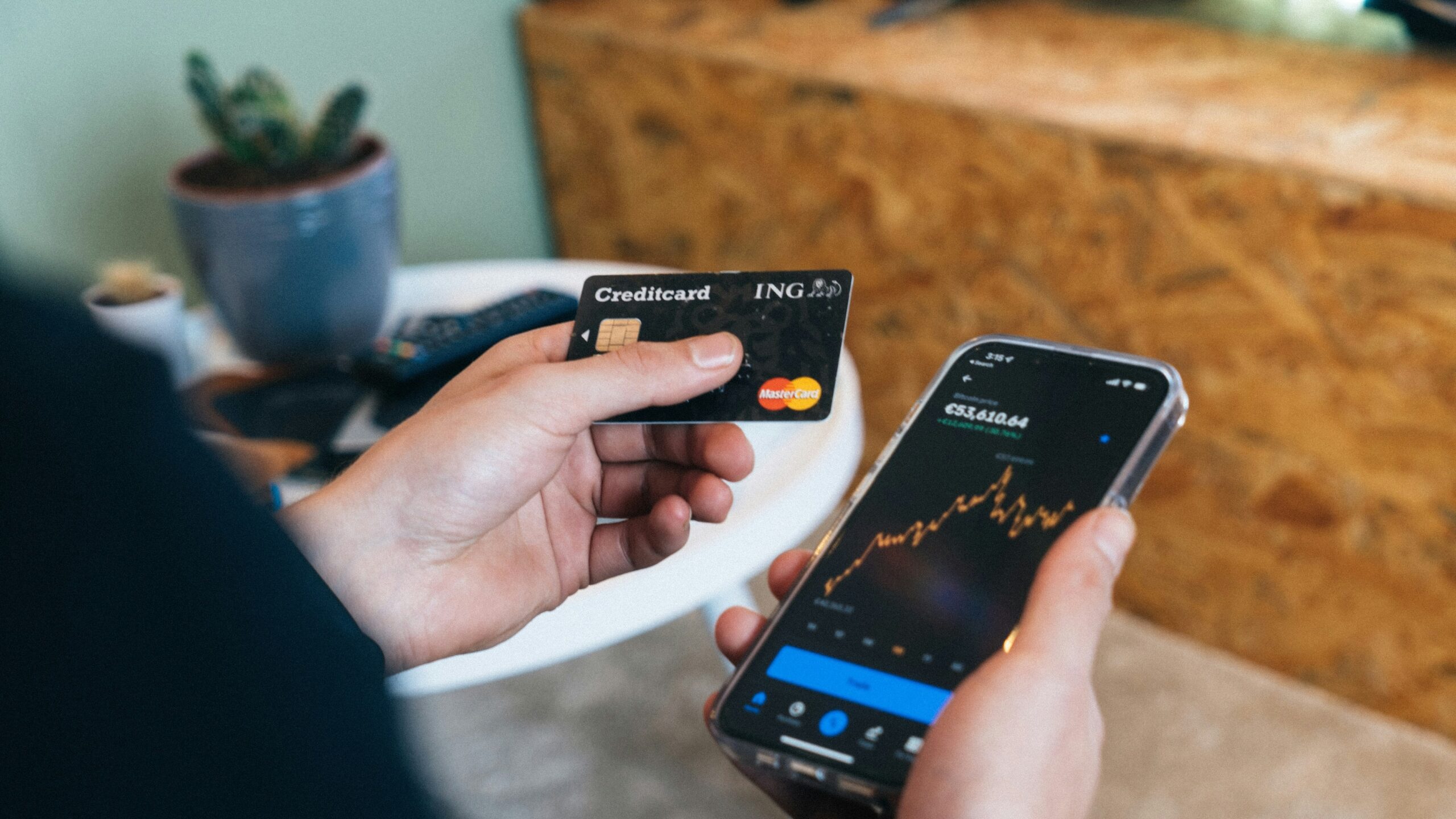 a person holding a smart phone and a credit card