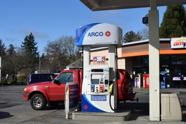 a red truck parked next to a gas station