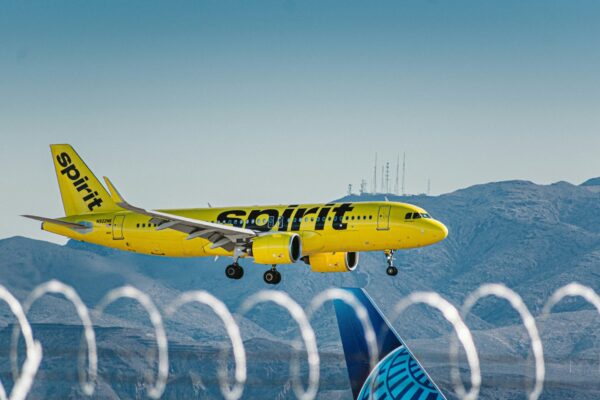 a yellow and blue jet airliner taking off from an airport