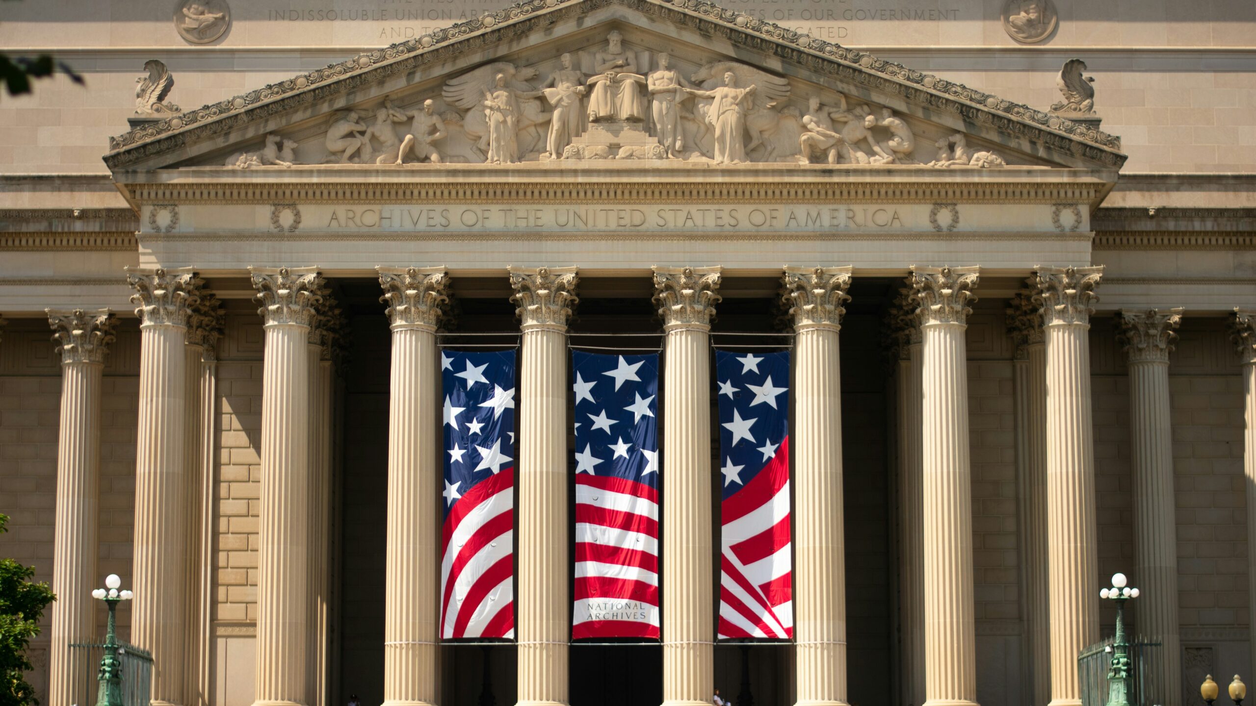 a building with columns and two american flags on it
