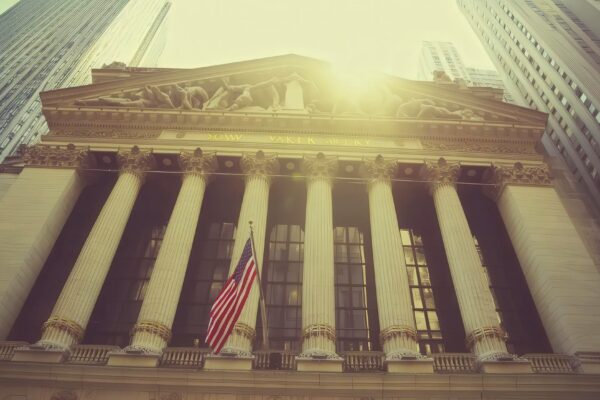 Historic facade of financial building with pillars and american flag in sunlight
