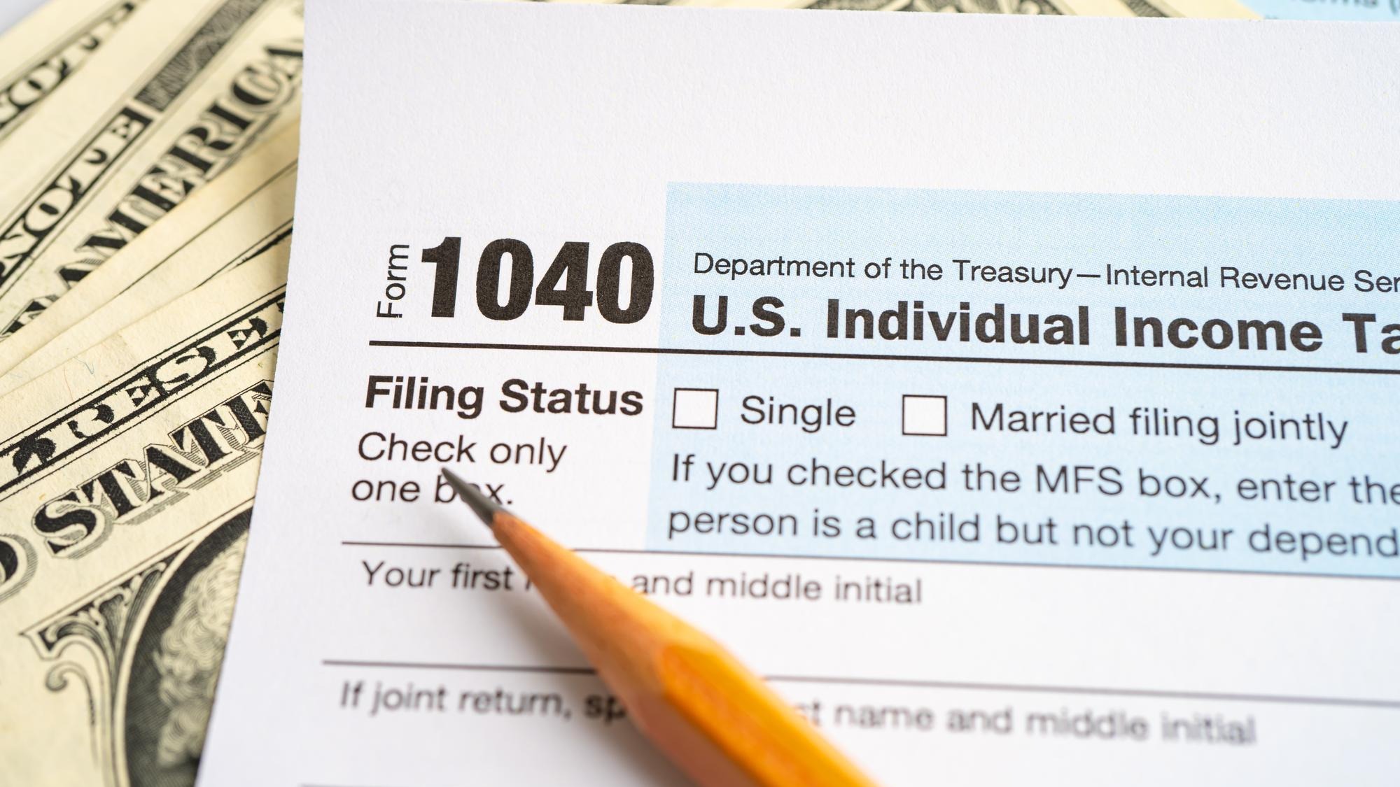 Tax Return form 1040 with USA America flag and dollar banknote US Individual Income