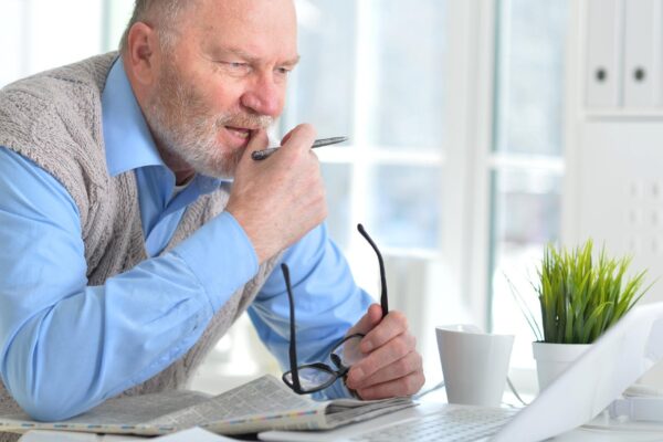 Portrait of an elderly man using a laptop in an office
