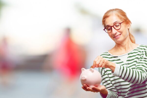 Senior beautiful woman with a piggy bank