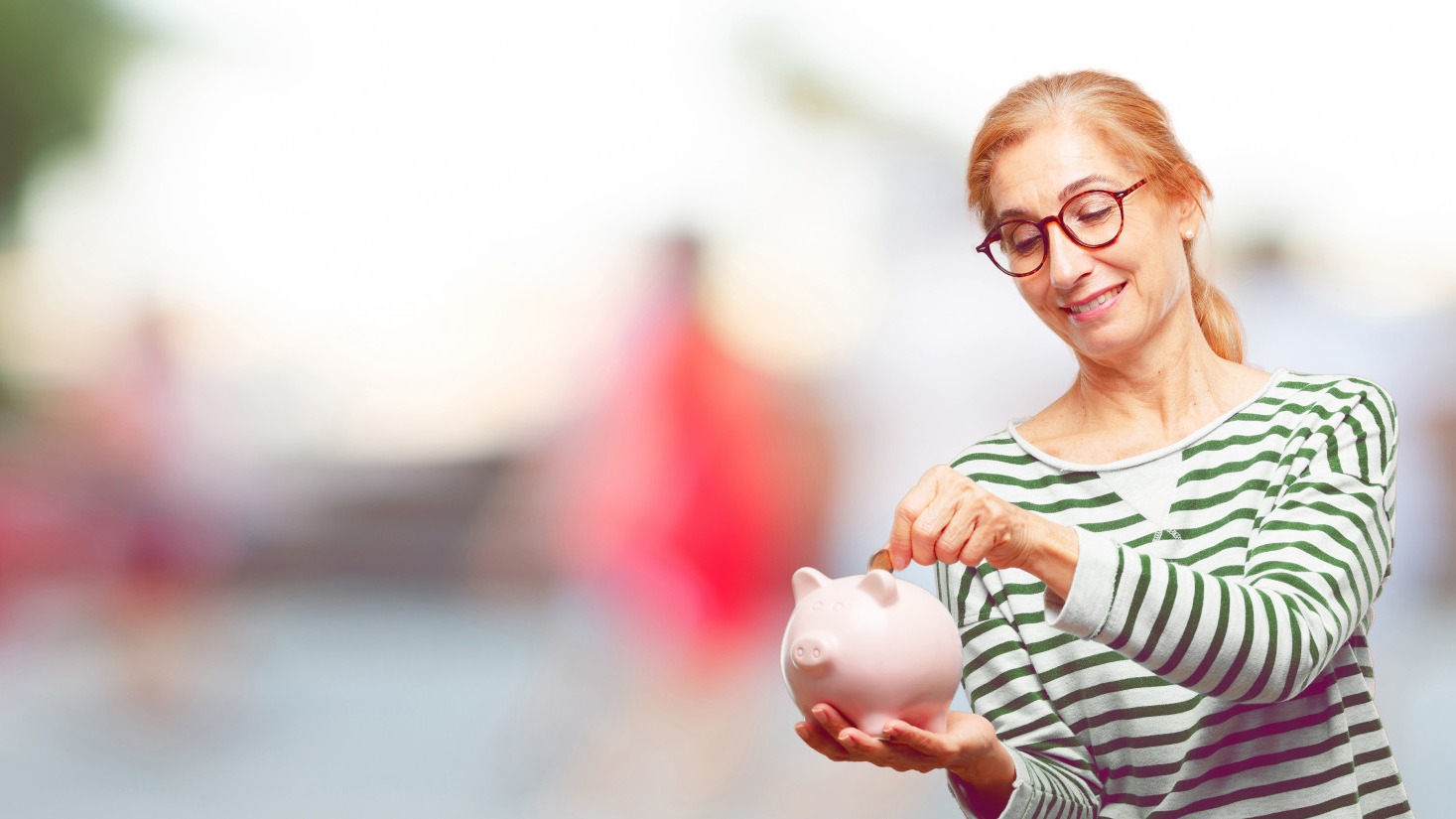 Senior beautiful woman with a piggy bank